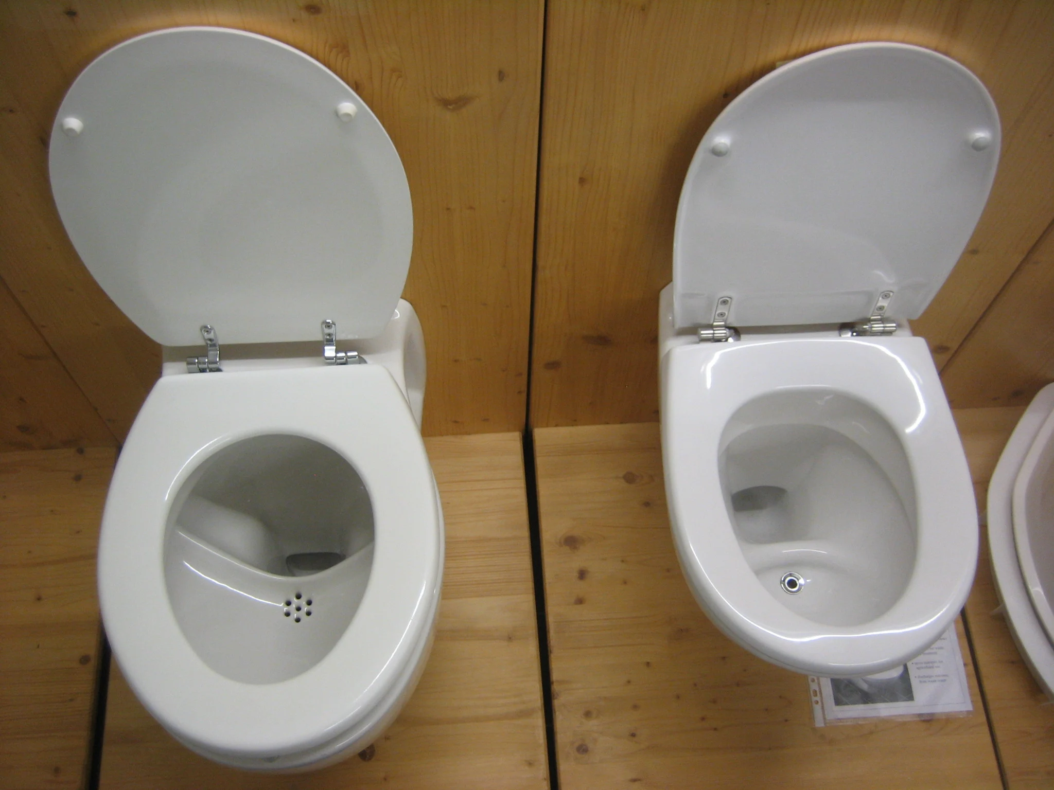 尿分離式水洗トイレ（UDFT）が2台横に並んでいる。見た目は普通の水洗トイレだが、便器の中央付近に尿を回収するための穴が備わっている。